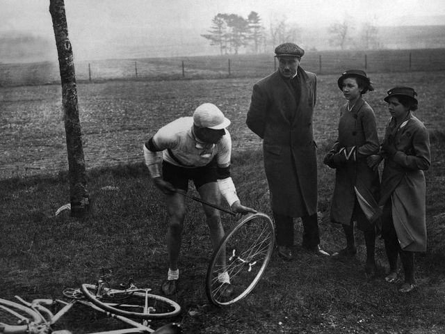 Young girls watching French cyclist Georges Speicher repairing his bike during Paris-Roubaix 1935