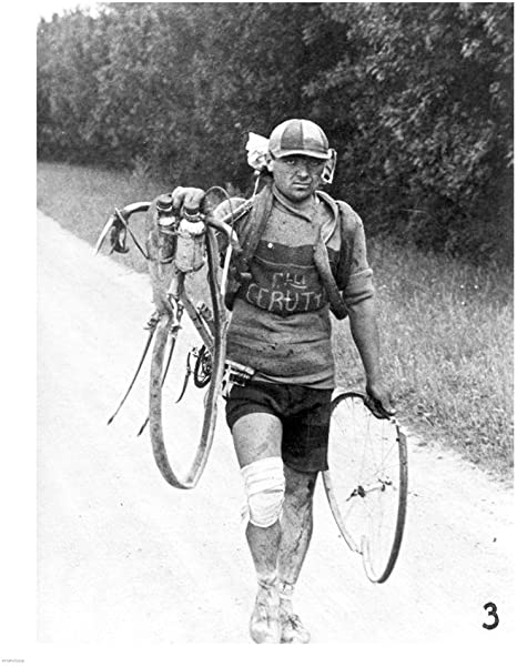 Grumpy cyclist Giusto Cerutti carrying his broken bicycle at Tour de France 1928. 