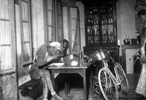 French cyclist Robert Jacquinot sitting at the table of a tavern, eating probably some soup during Tour de France 1922