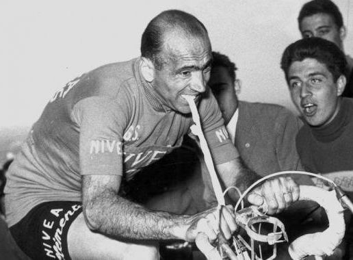Italian cyclist Fiorenzo Magni holdig an inner tube between his teeth during the Giro d'Italia 1956