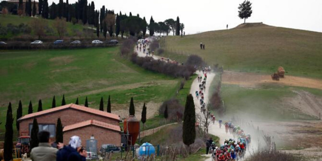 A moment from the scenic sping road cycling race Strade Bianche, when the peloton hits the white gravel road of the popular Tuscan hills in the middle of Italy.