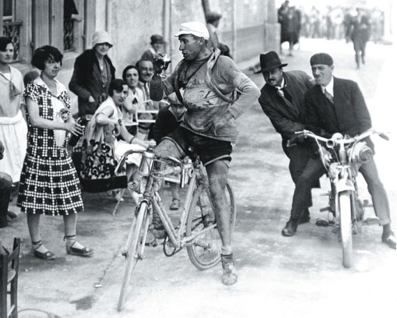 Giovanni Canova, an Italian cyclist attending the Tour de France in the 1920s stops for having a glas wine